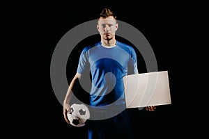 Young handsome football player soccer holds ball and white blank on white.