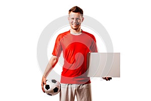 Young handsome football player soccer holds ball and white blank on white.