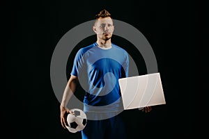 Young handsome football player soccer holds ball and white blank on white.