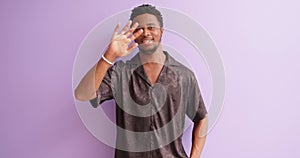 Young handsome friendly bearded African American man greets friends by waving hands