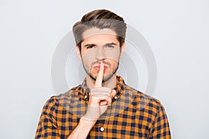 Young handsome guy in checkered shirt showing silent gesture