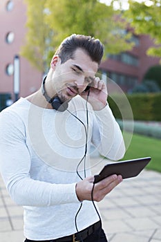 Man listening music by headphones in park enjoying rythm photo