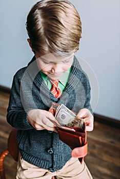 Young handsome guy looking happy while going through wallet