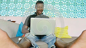 Young handsome and happy hipster black afro American business man working with laptop computer and headphones smiling satisfied