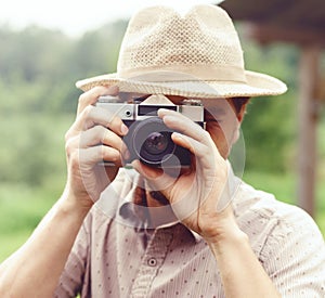 Young, handsome hippy taking pictures outdoors. Holiday, journey, trip, vacation concept.