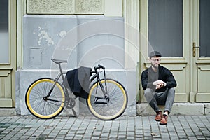 Young handsome hipster man sitting and posing and bicycle on the street