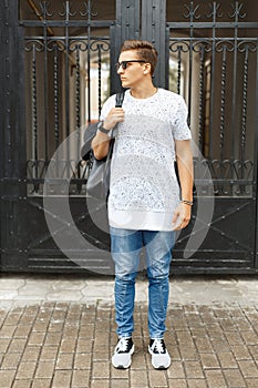 Young handsome hipster man in a white t-shirt, blue jeans