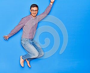 Young handsome hispanic businessman wearing glasses smiling happy