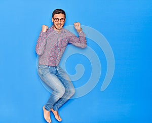 Young handsome hispanic businessman wearing glasses smiling happy