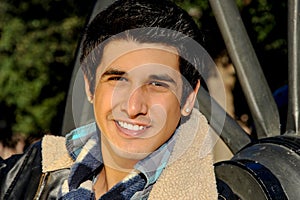 Young handsome hispanic male gives a beautiful smile that warms the cold winter`s day.