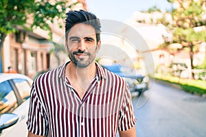 Young handsome hispanic man with beard smiling happy outdoors