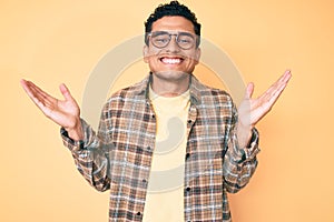 Young handsome hispanic man wearing casual clothes and glasses celebrating victory with happy smile and winner expression with