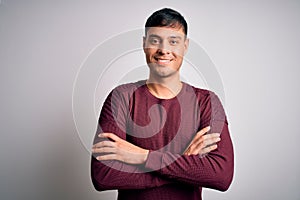 Young handsome hispanic man wearing casual shirt standing over white isolated background happy face smiling with crossed arms