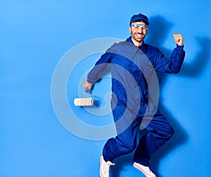 Young handsome hispanic man wearing painter uniform and cap smiling happy