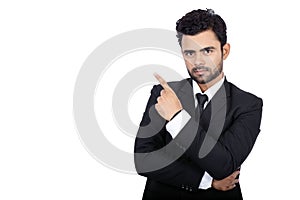 Young handsome Indian businessman wearing an elegant suit pointing at copy space