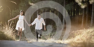 Young handsome Indian couple walking through field