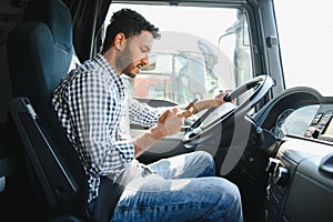 Young handsome indian man using smart phone in his truck.