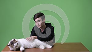 Young handsome Iranian teenage boy against green background