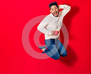 Young handsome latin man smiling happy drinking cup of coffee