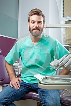 Young handsome male doctor with beard smiling with white teeth