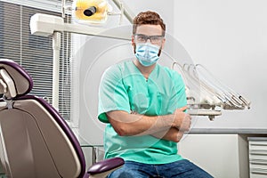 Young handsome male doctor wearing dentist mask and glasses