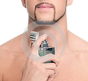 Young handsome man applying perfume