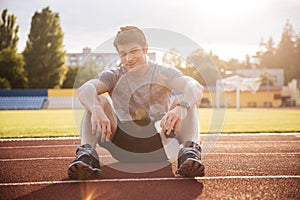 Young handsome man athlete resting with water bottle