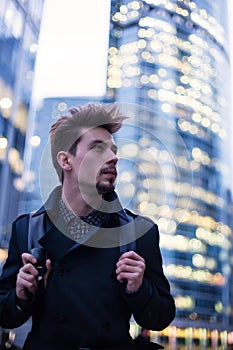 Young handsome man with backpack in big modern city