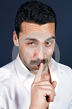 Young handsome man with beard and mustache showing hush sign