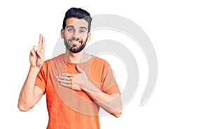 Young handsome man with beard wearing casual t-shirt smiling swearing with hand on chest and fingers up, making a loyalty promise