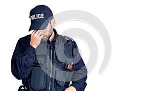 Young handsome man with beard wearing police uniform tired rubbing nose and eyes feeling fatigue and headache