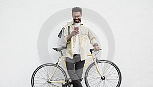 Young handsome man with bike over white wall background in a city, Smiling student men with bicycle smiling outdoor