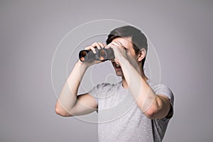 Young handsome man with binoculars isolated on white background