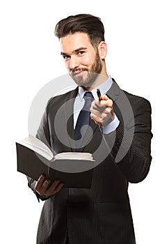 Young handsome man in black suit and business diary isolated