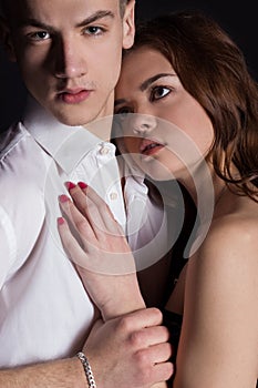 Young handsome man in a business suit and a white shirt in official style with beautiful girl, couple in love in the Studio