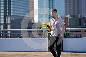 Young handsome man in classik polo t-shirt chatting on phone on the street. Handsome confident stylish hipster model