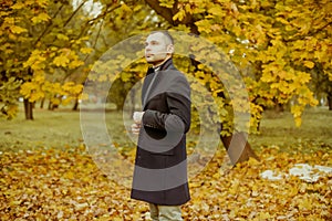 Young handsome man in coat. Fashionable well dressed man posing in stylish coat. Confident and focused boy outdoor at autumn.
