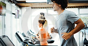 Young handsome man doing cardio training in gym