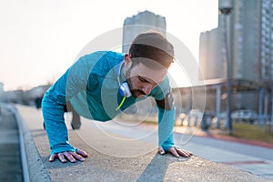 Young handsome man doing push ups outdoors