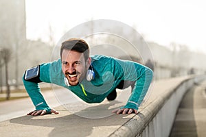 Young handsome man doing push ups outdoors