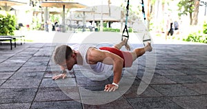 Young handsome man doing push-ups on street