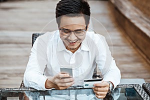 Young Handsome man enjoy shopping online on mobile phone with credit card