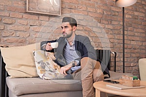 Young handsome man enjoying coffee espresso indoors interior
