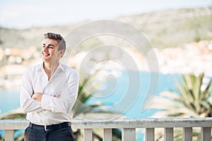 Young handsome man enjoying stay at luxury resort hotel with panoramic view on the sea