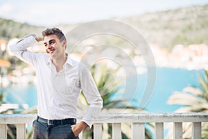 Young handsome man enjoying stay at luxury resort hotel with panoramic view on the sea