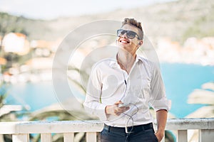 Young handsome man enjoying stay at luxury resort hotel with panoramic view on the sea