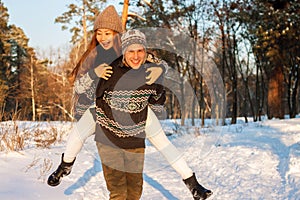 A young handsome man of European appearance and a young Asian girl in a park on the nature in winter. A