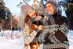 A young handsome man of European appearance and a young Asian girl in a park on the nature in winter