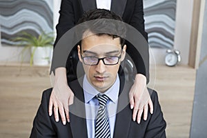 Young handsome man feeling discomfort because of his female boss inappropriate behaviour in the office