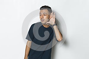 Young handsome man with hand over ear listening an hearing to gossip isolated on white background